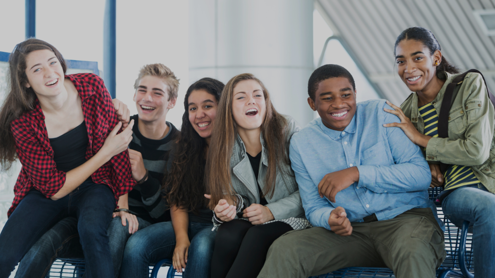 Diverse group of teenagers sitting and laughing